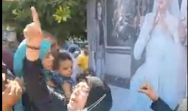 أنهى حياتها زوجها.. سيدة تحمل بنر لصورة ابنتها وتعلن تضامنها مع قضية «نيرة أشرف» 