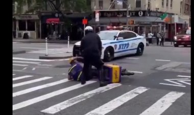 أثناء مرور موكب بايدن.. شرطي يدفع عامل دليفري من على دراجته بعنف