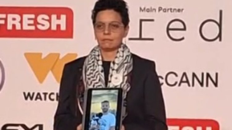 مي محمود سعد تحمل صورة المخرج الفلسطيني أحمد الدنف على السجادة الحمراء للقاهرة السينمائي