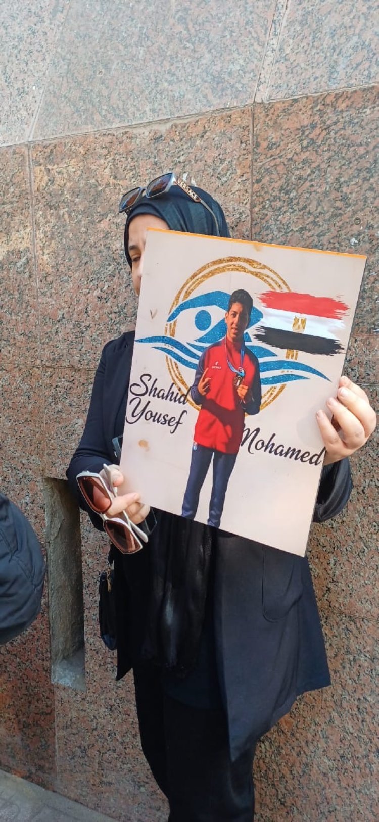 حاملة صورته.. والدة السباح الطفل يوسف أمام المحكمة في أولى جلسات محاكمة رئيس اتحاد السباحة وآخرين بتهمة الإهمال